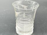 a shot glass with a fish in it on a table