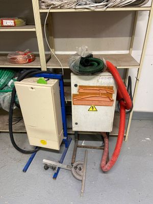 une machine posée par terre à côté d'une étagère