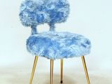 a blue chair with a gold legs on a white floor