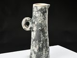 a black and white vase sitting on a white table