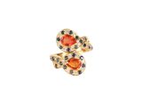 un gros plan d'une bague sertie d'une pierre orange et de saphirs bleus