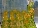 un plateau en verre vert sur lequel sont posés des verres à vin et une bouteille
