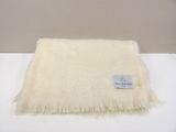 white blanket with a tag on it sitting on a white table