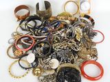 a pile of assorted rings and bracelets on a table