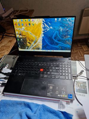 un ordinateur portable posé sur un bureau, à côté d'une serviette bleue