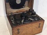 un tourne-disque à l'ancienne dans un coffret en bois, posé sur une surface blanche