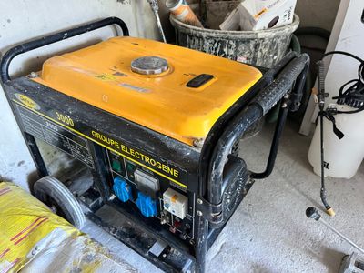yellow and black generator sitting on top of a cart in a garage