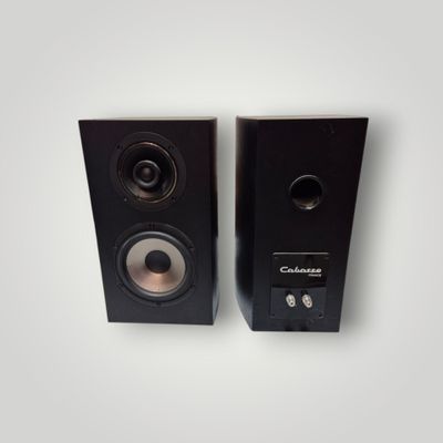 pair of black speakers on a white surface with a white background