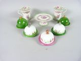 five small dishes and cups sitting on a table