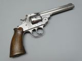 a close up of a revolver on a table with a wooden handle