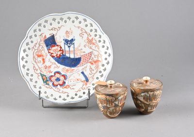 two vases and a plate on display on a table