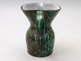 a green vase that is sitting on a white surface