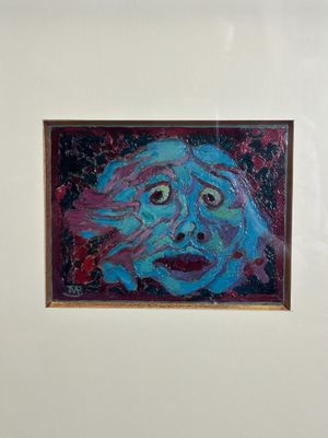 une photo d'un tableau représentant un visage accroché au mur