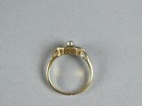 a close up of a gold ring with a diamond on it
