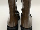 a pair of brown boots with black soles on a white background