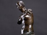 a bronze statue of a woman holding a flower in her hand
