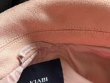 a close up of a pink jacket with a black label on it