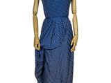 mannequin vêtu d'une robe bleue, exposé sur un socle en bois
