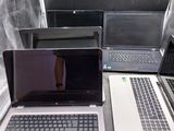 Trois ordinateurs portables sont posés sur une table ; l'un est ouvert et l'autre fermé.