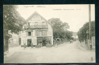 une vieille photo en noir et blanc d'un immeuble situé à l'angle d'une rue
