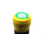 a close up of a bottle of wine with a yellow cap