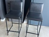pair of black leather bar stools in front of a kitchen island