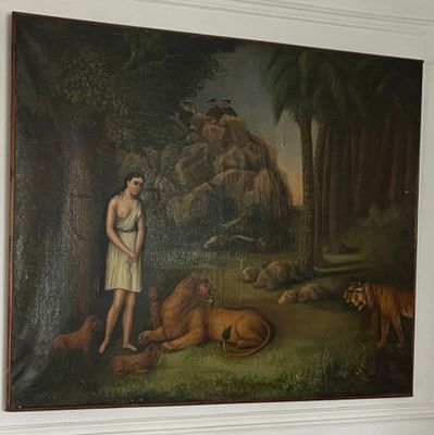 un tableau accroché au mur d'une pièce, représentant un homme et un tigre