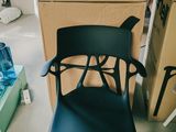 une chaise noire posée devant une pile de cartons