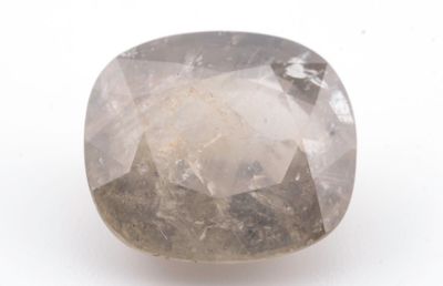 un gros plan d'un diamant brut blanc sur une surface blanche