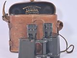a brown leather case with a pair of binoculars in it