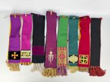 several different colored scarves hanging on a white wall