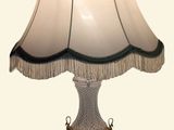 une lampe posée sur une table, avec un abat-jour blanc