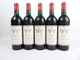 quatre bouteilles de vin sont alignées sur une surface blanche