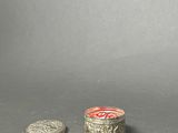 two silver coins sitting next to each other on a gray surface