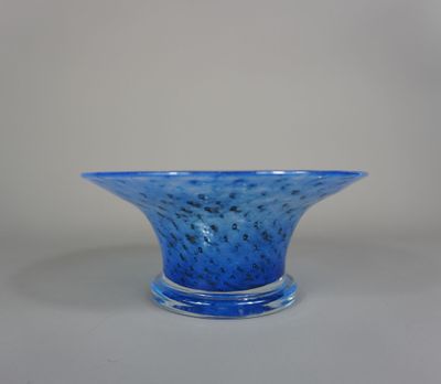 un saladier en verre bleu posé sur une table blanche