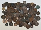 une pile de pièces de monnaie posée sur une table à côté d'un téléphone portable