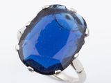 une photo d'une bague sertie d'une grosse pierre bleue