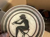 someone holding a plate with a black and white image of a man sitting on a chair