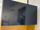 a television mounted on a yellow shelf in the corner of a room
