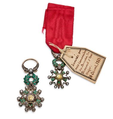 une photo représentant une paire de boucles d'oreilles et un ruban muni d'une étiquette