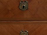 a wooden chest of drawers with a marble top
