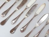 a lot of silverware on a table with spoons and knives