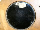 un miroir rond posé sur une table en bois, sur laquelle est accrochée une étiquette