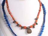 collier composé de perles bleues et orange, orné d'un pendentif en forme d'éléphant en argent