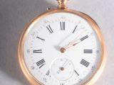 une montre de poche en or avec des chiffres romains