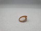 a close up of a gold ring on a white surface