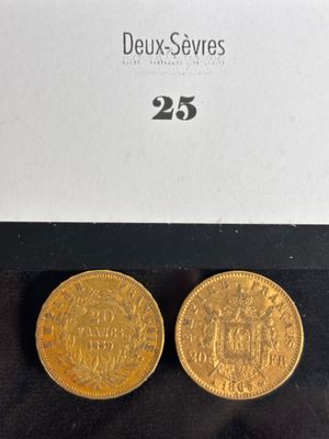 a pair of two gold coins sitting on top of a black surface