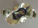 a silver vase with a purple stone inside of it