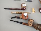 many different types of smoking pipes on the table