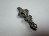 a small metal object that is on a white surface
